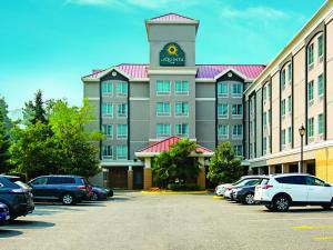 un hotel con una torre dell'orologio in cima a un parcheggio di La Quinta Inn by Wyndham Vancouver Airport a Richmond