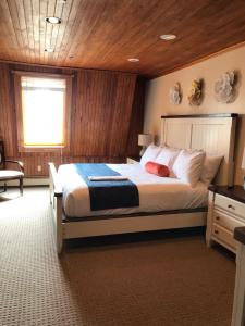 a bedroom with a large bed with a wooden ceiling at The Lighthouse Inn & Carriage House in York Beach