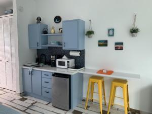 a kitchen with a counter and two yellow stools at The Beach Pad in Rincon