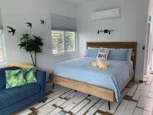 ein Schlafzimmer mit einem Bett und einem blauen Sofa in der Unterkunft The Beach Pad in Rincon