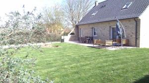 una casa con dos bancos y un patio de hierba en la maison du bonheur, en Roquetoire