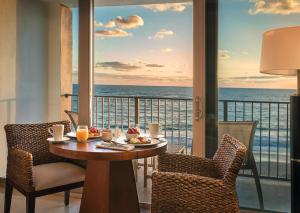 ein Esszimmer mit einem Tisch und Meerblick in der Unterkunft Costa d'Este Beach Resort & Spa in Vero Beach