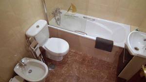 a bathroom with a toilet and a sink and a tub at Areias do Douro GuestHouse in Gondomar +30 photos