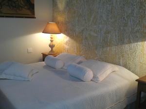 a white bed with white pillows and a lamp at Pousada da Mantiqueira in Visconde De Maua +45 photos