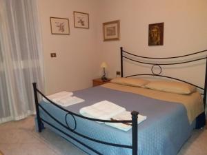 1 dormitorio con 1 cama grande y 2 toallas. en B&B Villa Pegaso, en Fontane Bianche