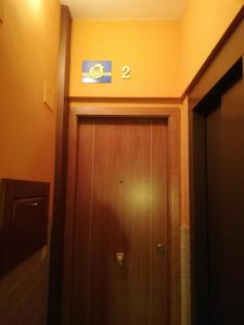 un baño con una puerta de madera con una señal encima en PENSIÓN PEÑA, en Burgos