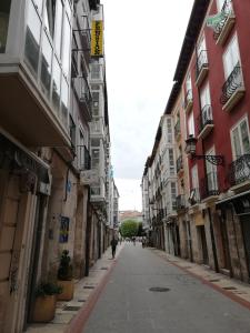 een persoon die over een straat tussen gebouwen loopt bij PENSIÓN PEÑA in Burgos