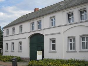 シュテンダールにあるPension Belau's Hofの緑の扉のある古い白い家