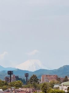 - une vue sur une montagne enneigée dans une ville dans l'établissement APA Hotel Hachioji Eki Nishi, à Hachioji