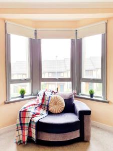 a bedroom with a bed and two windows at Three Bed Holiday Home in Glasgow in Glasgow