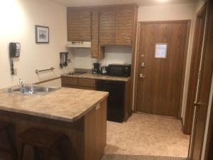 a kitchen with a sink, stove, refrigerator and cabinets at The Landing Resort in Egg Harbor