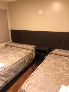 Pokój z dwoma łóżkami i małym stołem w obiekcie Crystal Hotel w mieście La Quiaca