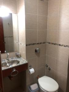 a bathroom with a toilet and a sink and a mirror at Crystal Hotel in La Quiaca