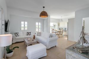 a living room with two white couches and a table at Seaside Naxos • Holiday Villas in Plaka