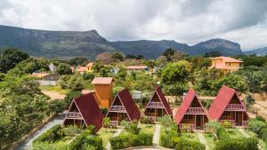 a cluster of houses with mountains in the background at Pousada e Hostel Pé no Mato in Vale do Capao