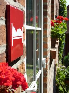 a sign on the side of a building with a window at Pension Kunsthof Dahrenstedt in Dahrenstedt