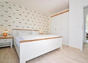 een slaapkamer met een wit bed en een bakstenen muur bij Villa Doris Bng 8 Hanau in Heringsdorf