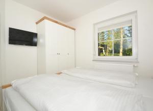 Cette chambre blanche dispose de 2 lits et d'une fenêtre. dans l'établissement Villa Doris Bng 9 Auritz, à Heringsdorf