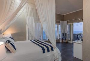 a bedroom with a canopy bed with a view of the ocean at Bayu Cottages in Amed