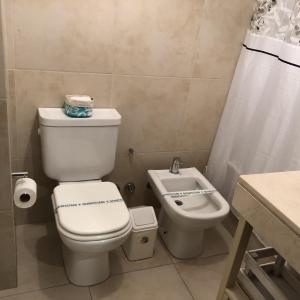a bathroom with a toilet and a sink at Metropolitan Lacroze in Buenos Aires
