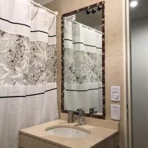 uma casa de banho com um lavatório e um espelho em Metropolitan Lacroze em Buenos Aires