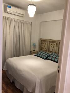 sypialnia z dużym białym łóżkiem i oknem w obiekcie Metropolitan Lacroze w BuenosAires