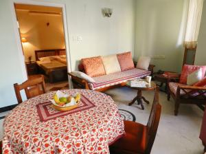 uma sala de estar com uma mesa com uma taça de fruta em Om Niwas Suite Hotel em Jaipur