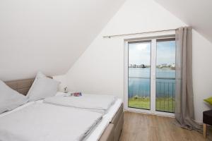 a bedroom with a bed and a large window at Sunshine in Olpenitz