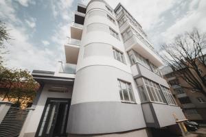 a white building with a white column at Apart-hotel Kostjukowski Apartments Nizhynska 17 in Lviv