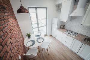 uma cozinha com uma mesa e cadeiras e uma parede de tijolos em Apart-hotel Kostjukowski Apartments Nizhynska 17 em Lviv