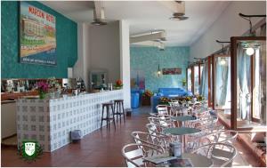 a restaurant with tables and chairs and a bar at Hotel Marconi in Grottammare