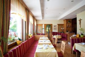 a restaurant with tables and chairs in a room at Pension Schierl in Faistenau