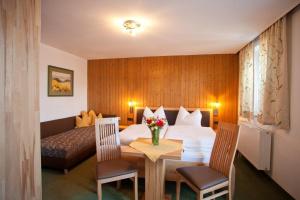 a hotel room with a bed and a table and chairs at Pension Schierl in Faistenau