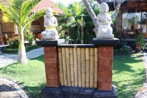 班尤溫當的住宿－Be Bali Menjangan，上面有雕像的栅栏
