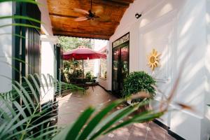 a house with a patio with an umbrella and plants at Rosa Hanoi Hotel in Hanoi