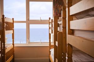 Zimmer mit 2 Etagenbetten und einem Fenster in der Unterkunft Berties Lodge in Newquay