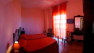 a bedroom with a red bed and a window at La Casa Di Mirò in Catanzaro Lido