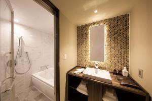 a bathroom with a sink and a tub and a mirror at Shibuya Stream Excel Hotel Tokyu in Tokyo