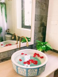 會安的住宿－Xanh Lá Homestay Hội An，浴室设有红色鲜花的水槽