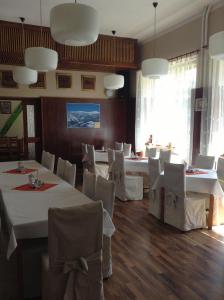 un comedor con mesas blancas y sillas blancas en Hotel Krakonos en Rokytnice nad Jizerou