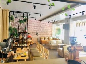 a room with tables and chairs and a brick wall at Hoa Sua Hotel in Vung Tau