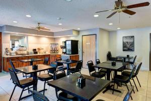 a restaurant with tables and chairs and a kitchen at SureStay Plus Hotel by Best Western Redding in Redding