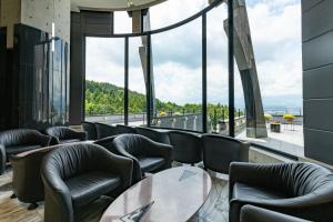 um restaurante com cadeiras e mesas e uma grande janela em Rembrandt Premium Fuji Gotenba em Gotemba