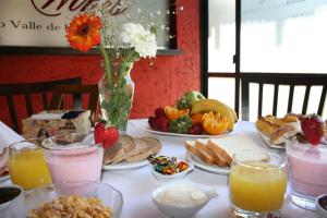 Hotel Tunuyan في تونويان: طاولة مليئة بأطباق الطعام و مزهرية من الزهور
