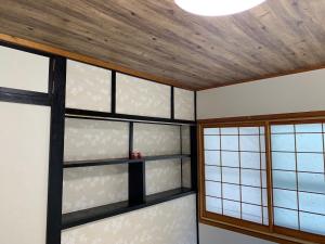 een kamer met ramen en een houten plafond bij Condominium WAFU TEI Okinawa city in Okinawa City