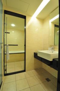 a bathroom with a sink and a shower at Goodness Plaza Hotel in Taishan