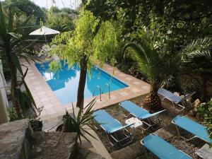 uma piscina com espreguiçadeiras azuis ao lado em Mikros Paradisos em Somatás