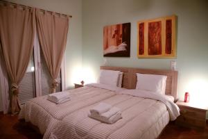 a bedroom with a large bed with two towels on it at Patras Cozy Lodge in Patra