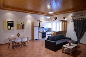 ein Wohnzimmer mit einem Sofa und einem Tisch sowie eine Küche in der Unterkunft Patras Cozy Lodge in Patras