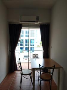 a dining room with a table and chairs and a window at Avatara condo B22 A in Mae Pim